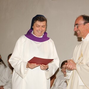 Pfarrer Johann Karner überreicht Sr. Maria das Dekret zur Wort-Gottes-Feier-Leiterin. Sie trägt erstmals eine weiße Albe.